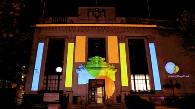 Living Wage Week projection mapping on Islington Town Hall — colourful geometric shapes illuminating the building facade at night
