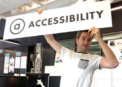 Gerred holding the ASOS Accessibility sign in the design studio
